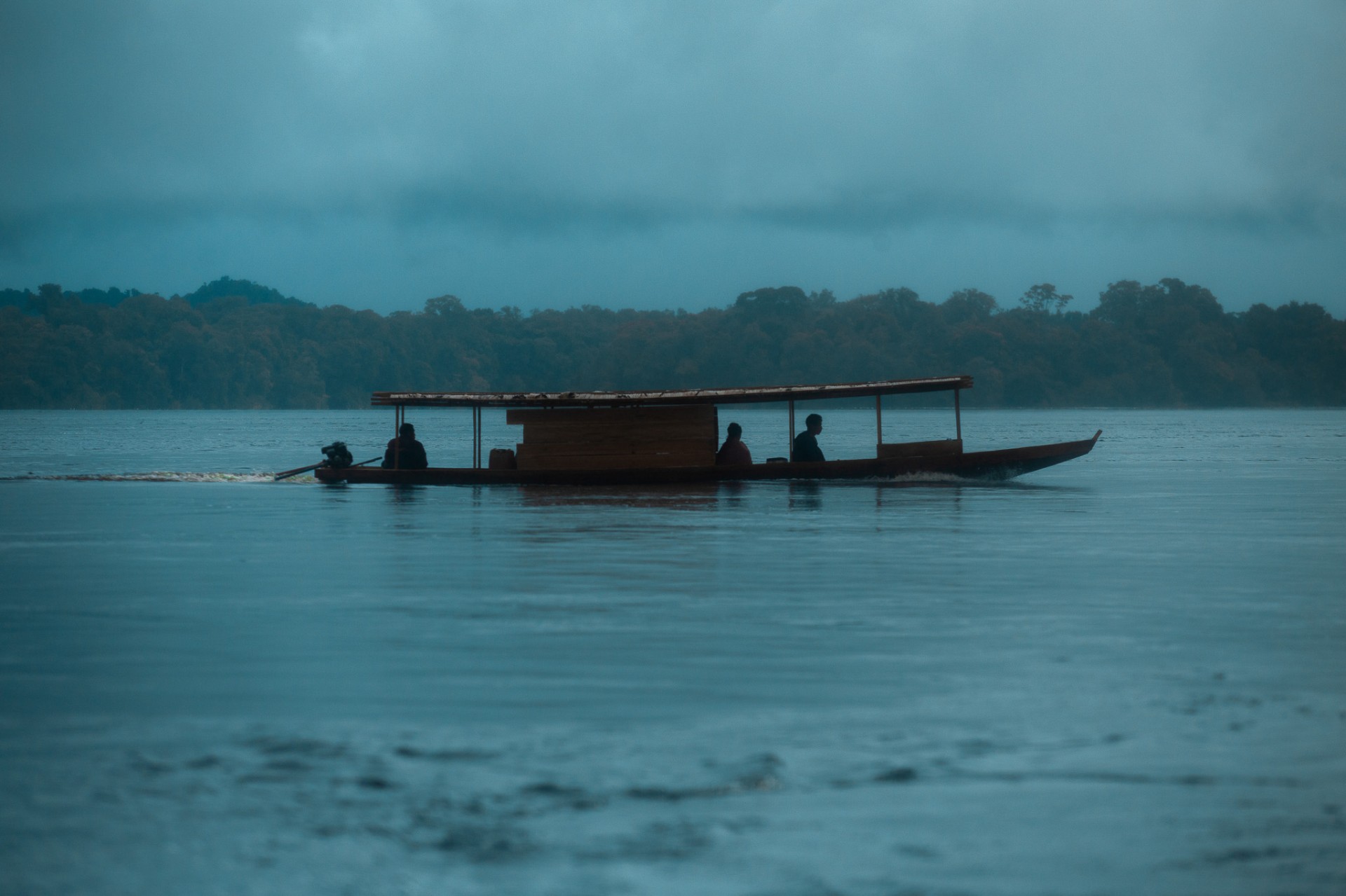 Barco navegando al atardecer en el río amazónico