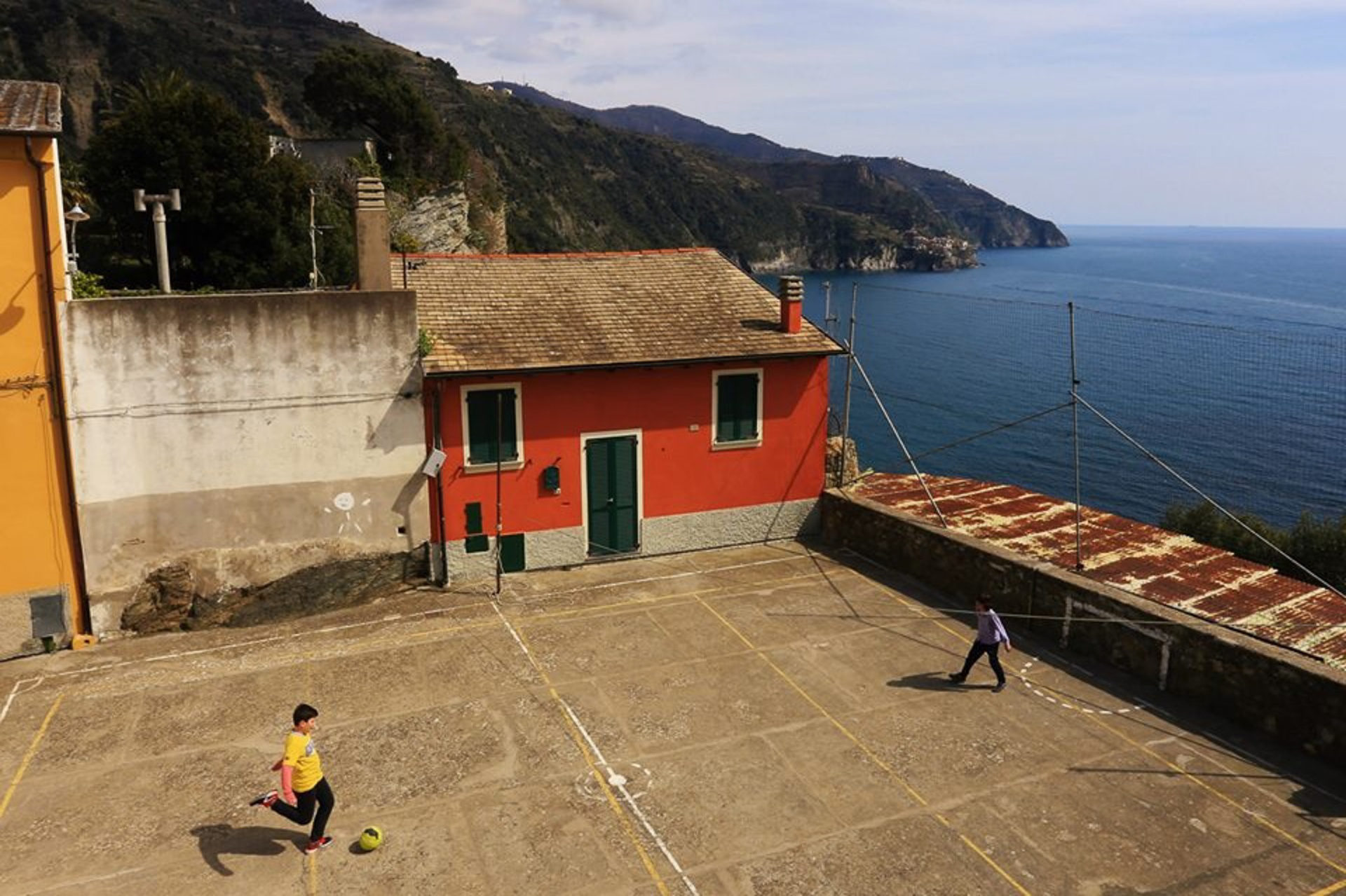 Niños jugando al fútbol en cancha sobre el acantilado