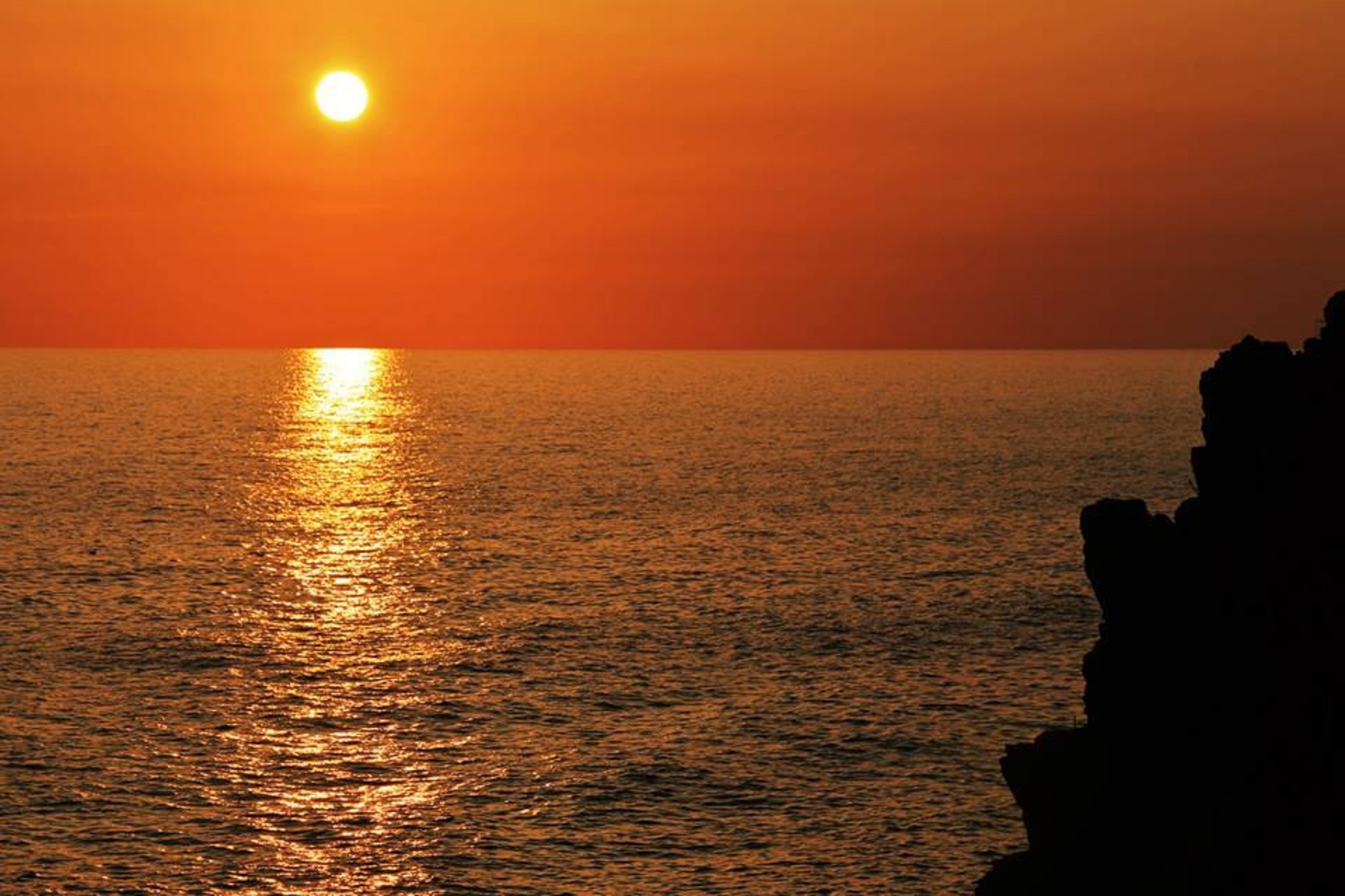 Sol naranja reflejado en el mar