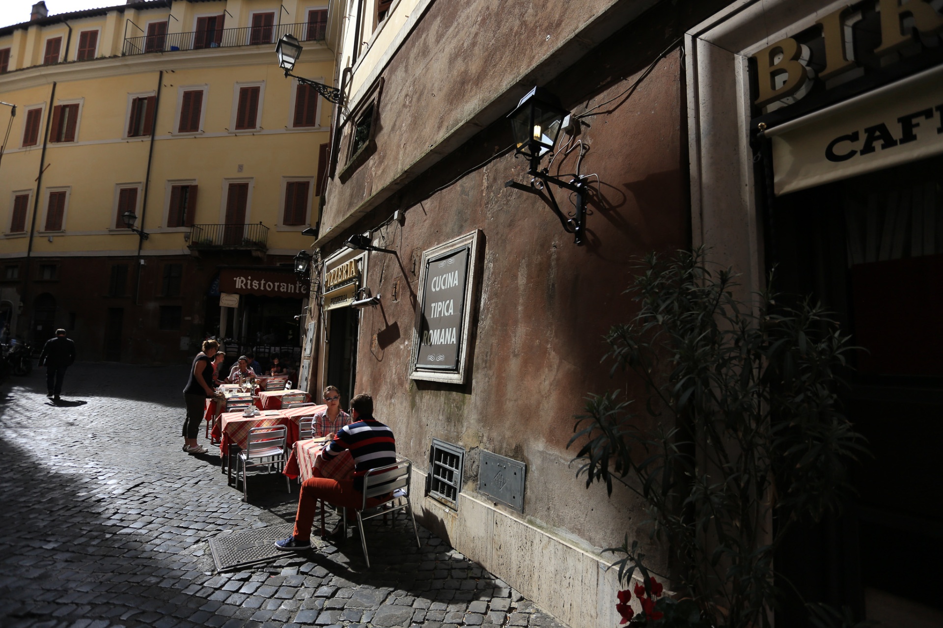 Cucina típica romana, mesas en callejón empedrado