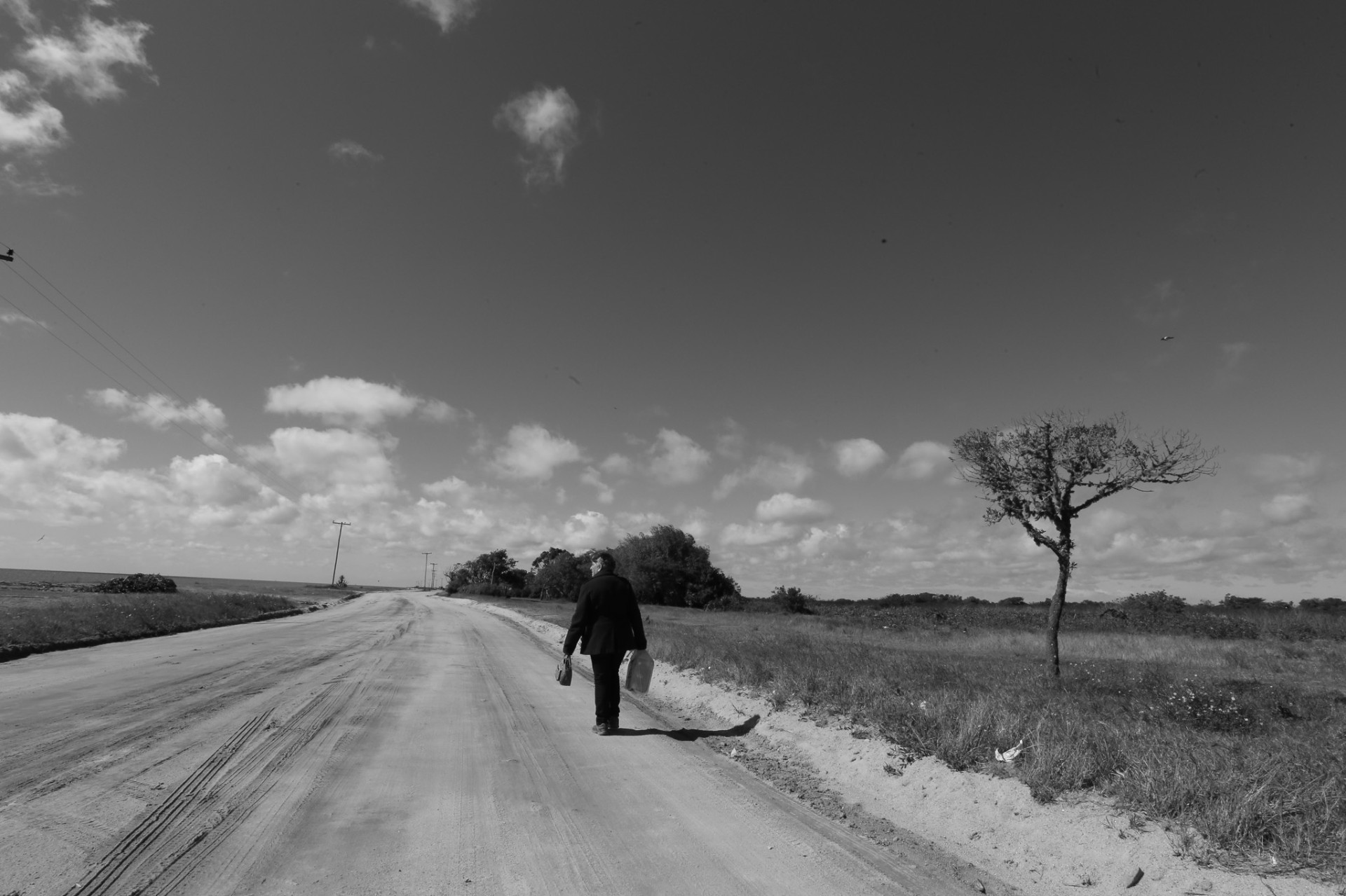 Caminante en la ruta de tierra, cielo abierto