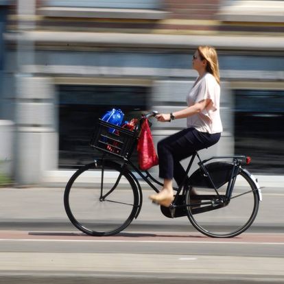Mujer en bicicleta cruzando una calle de Ámsterdam
